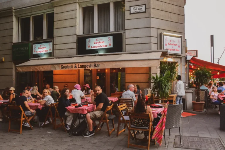 Gäste an Tischen mit karierten Tischdecken auf der Terrasse in der Duna utca