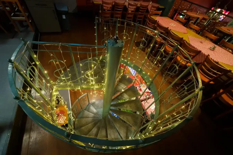 Eine Wendeltreppe mit warmen Lichtern im Haus am Ferenciek tere